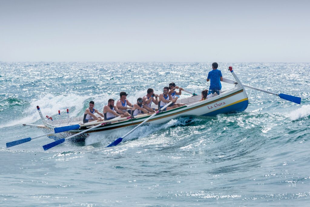 group of men rowing through waves